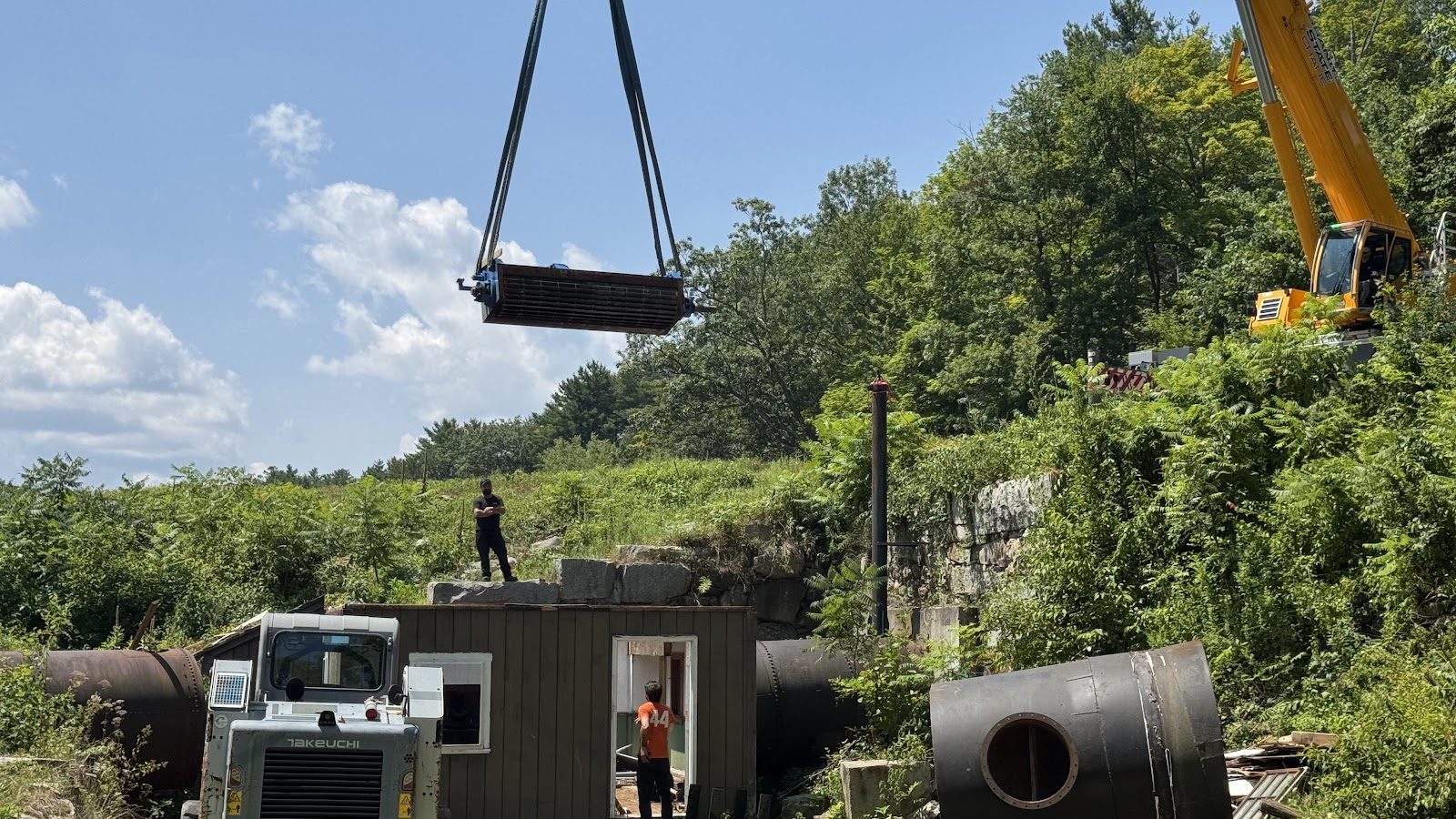 A lift swinging in over the work area.